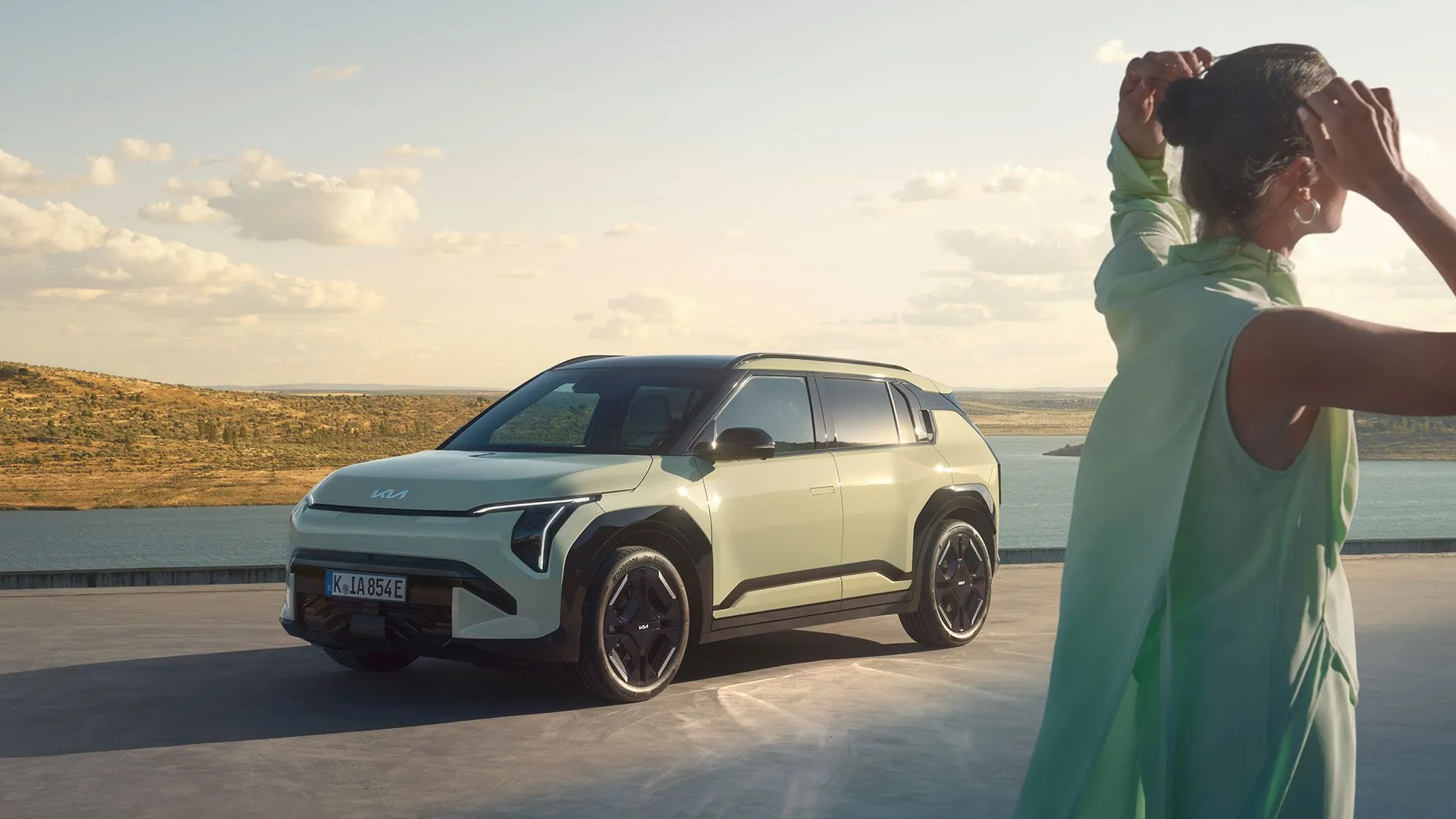 Kia EV3 a žena na terase u moře