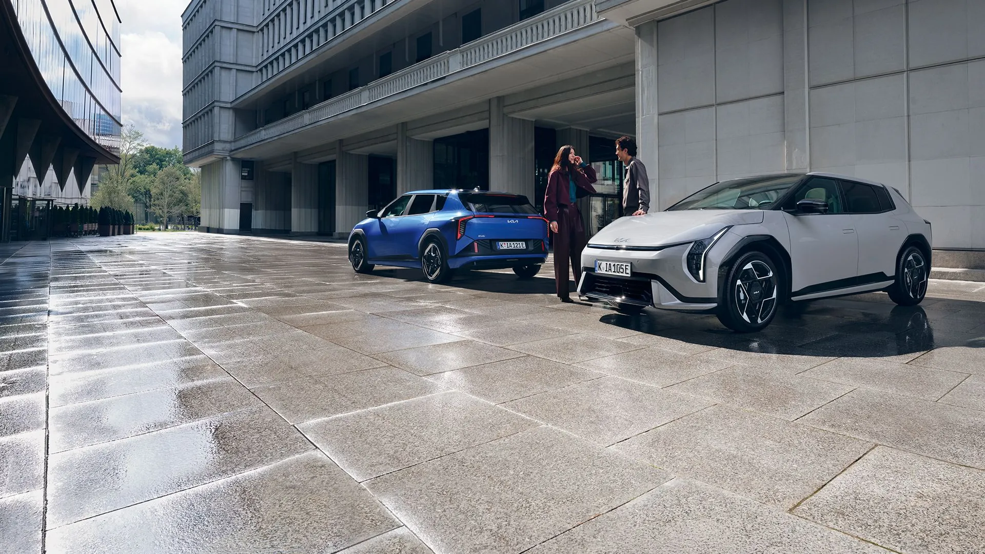 Modrá a stříbrná Kia EV4 v mokré ulici
