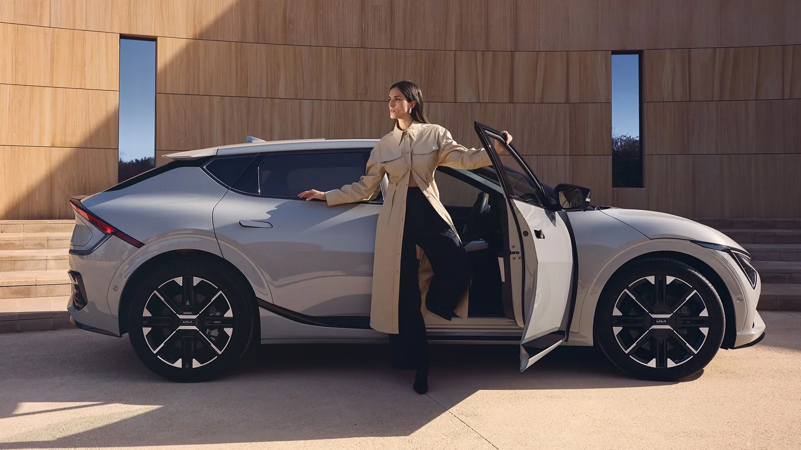 Kia EV6 z boku a žena v otevřených dveřích