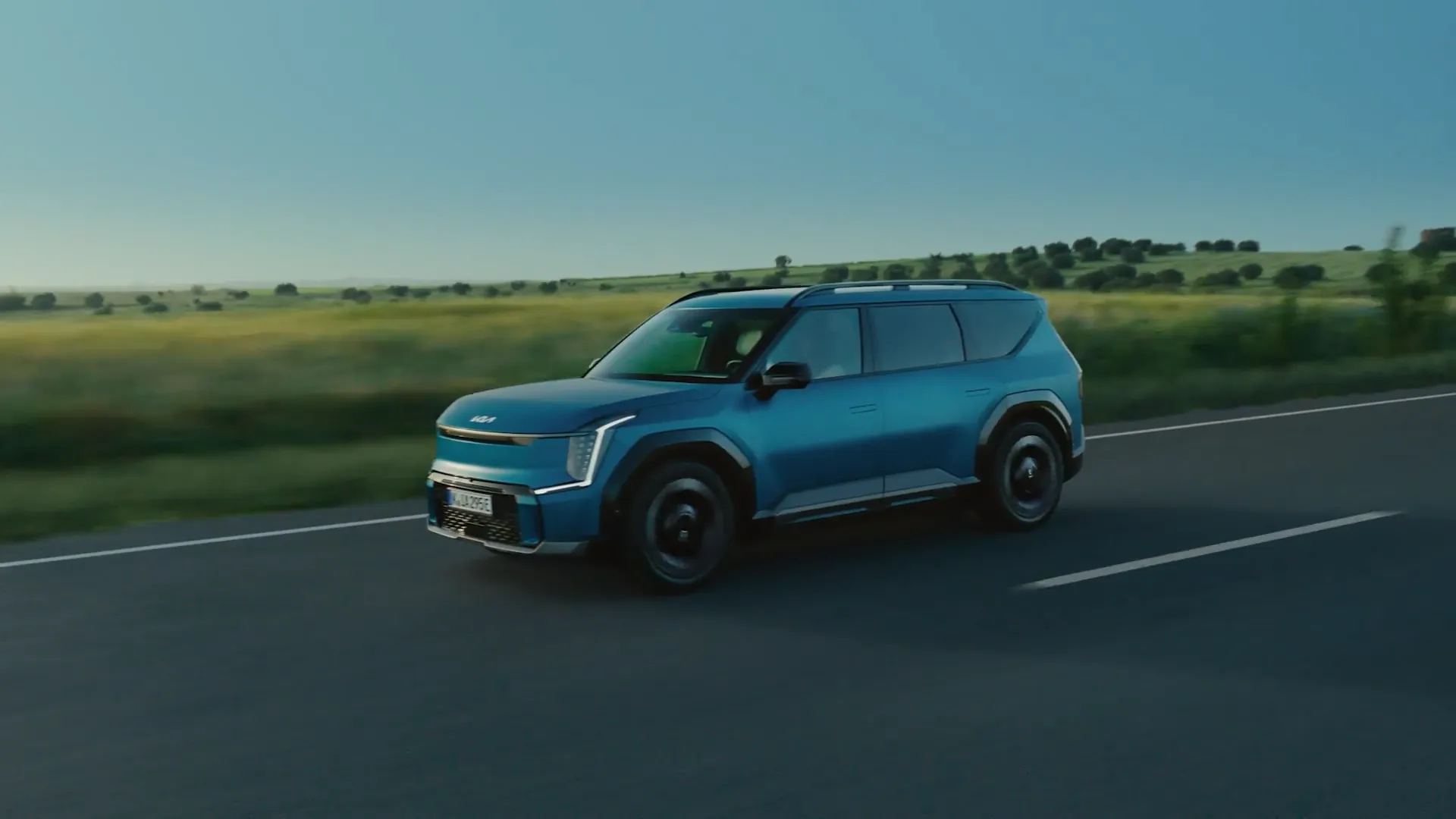 Modrá Kia EV9 v jízdě krajinou