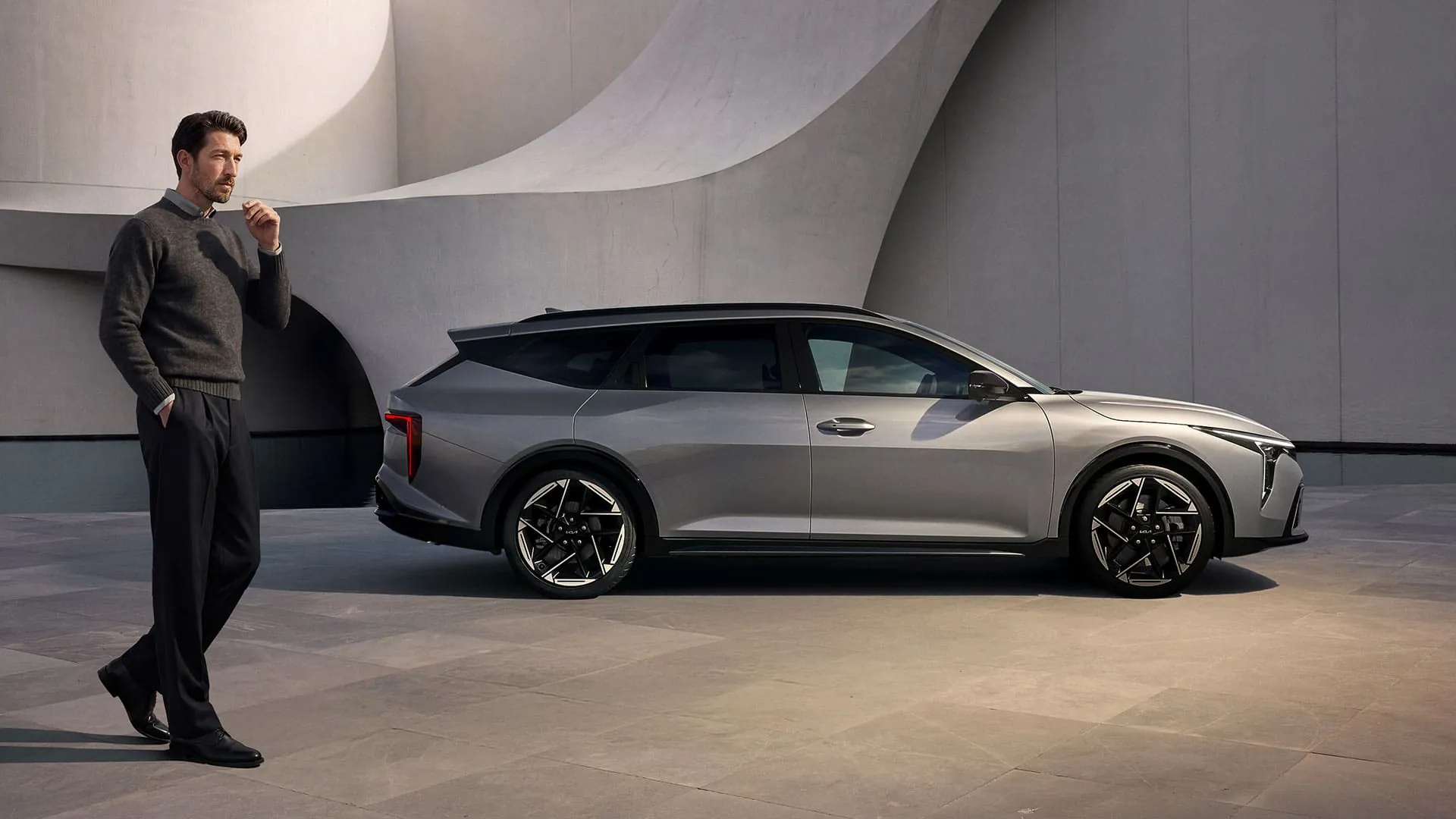 Kia K4 Sportswagon a muž u moderní stavby