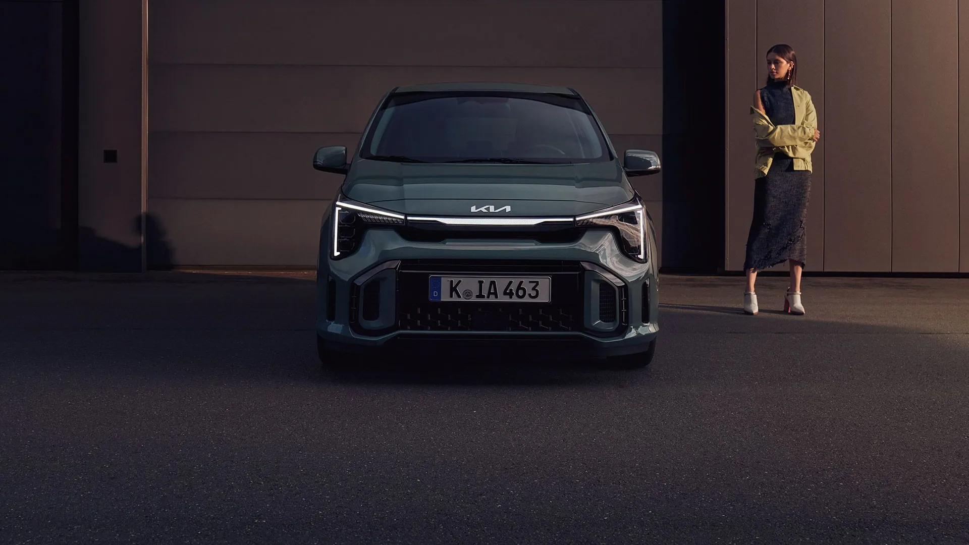 Kia Picanto zepředu a žena u stěny