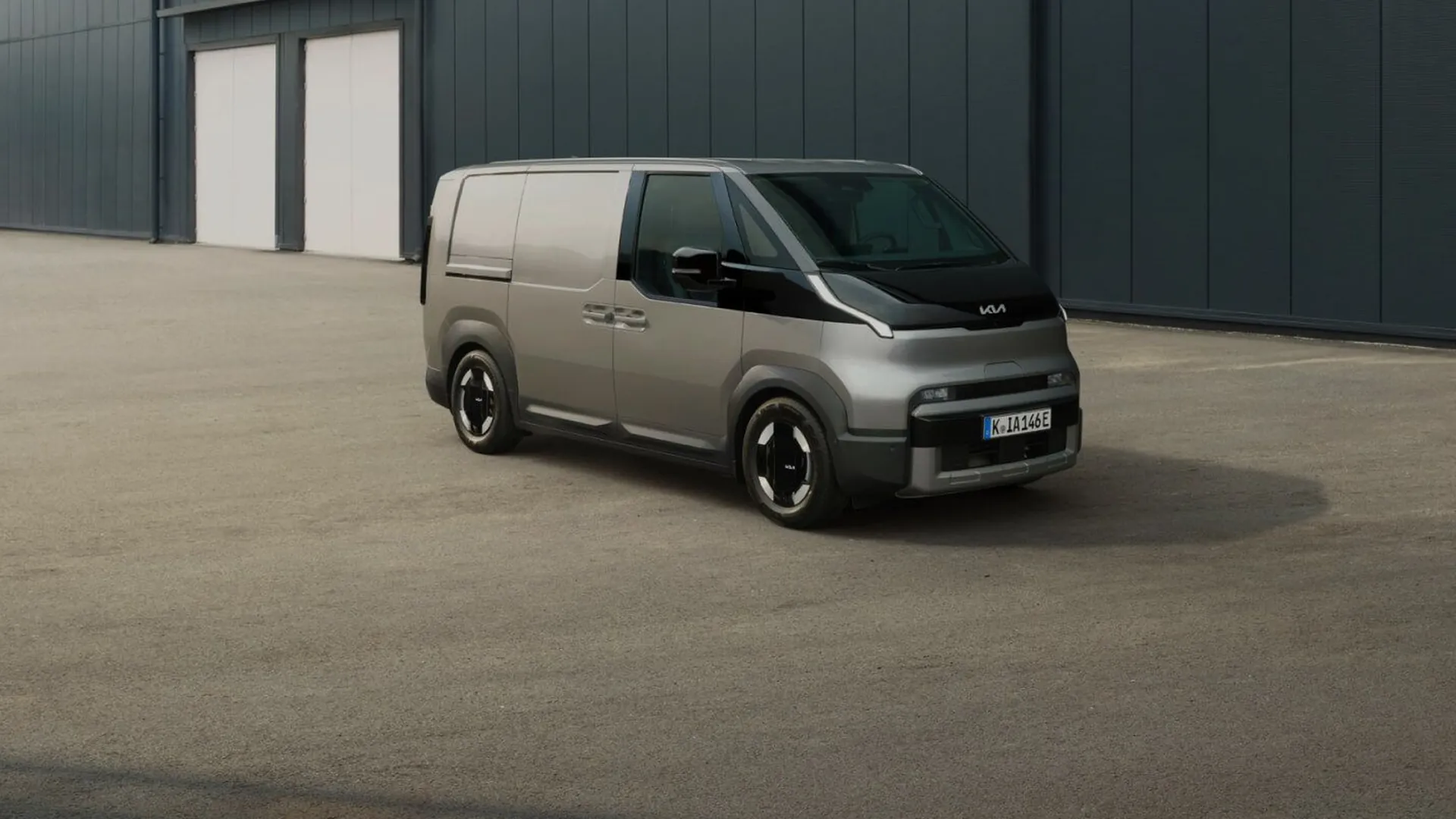 Šedá Kia PV5 Cargo před skladovou halou