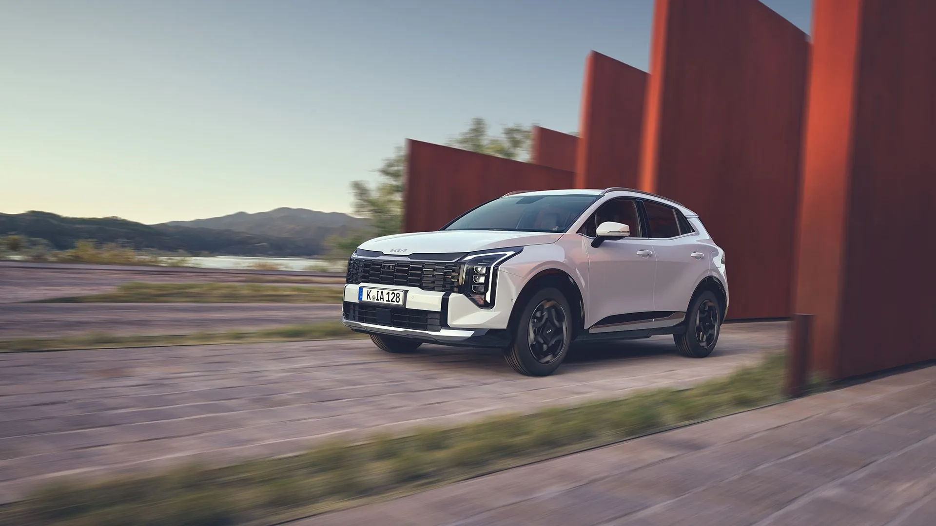 Bílá Kia Sportage v jízdě